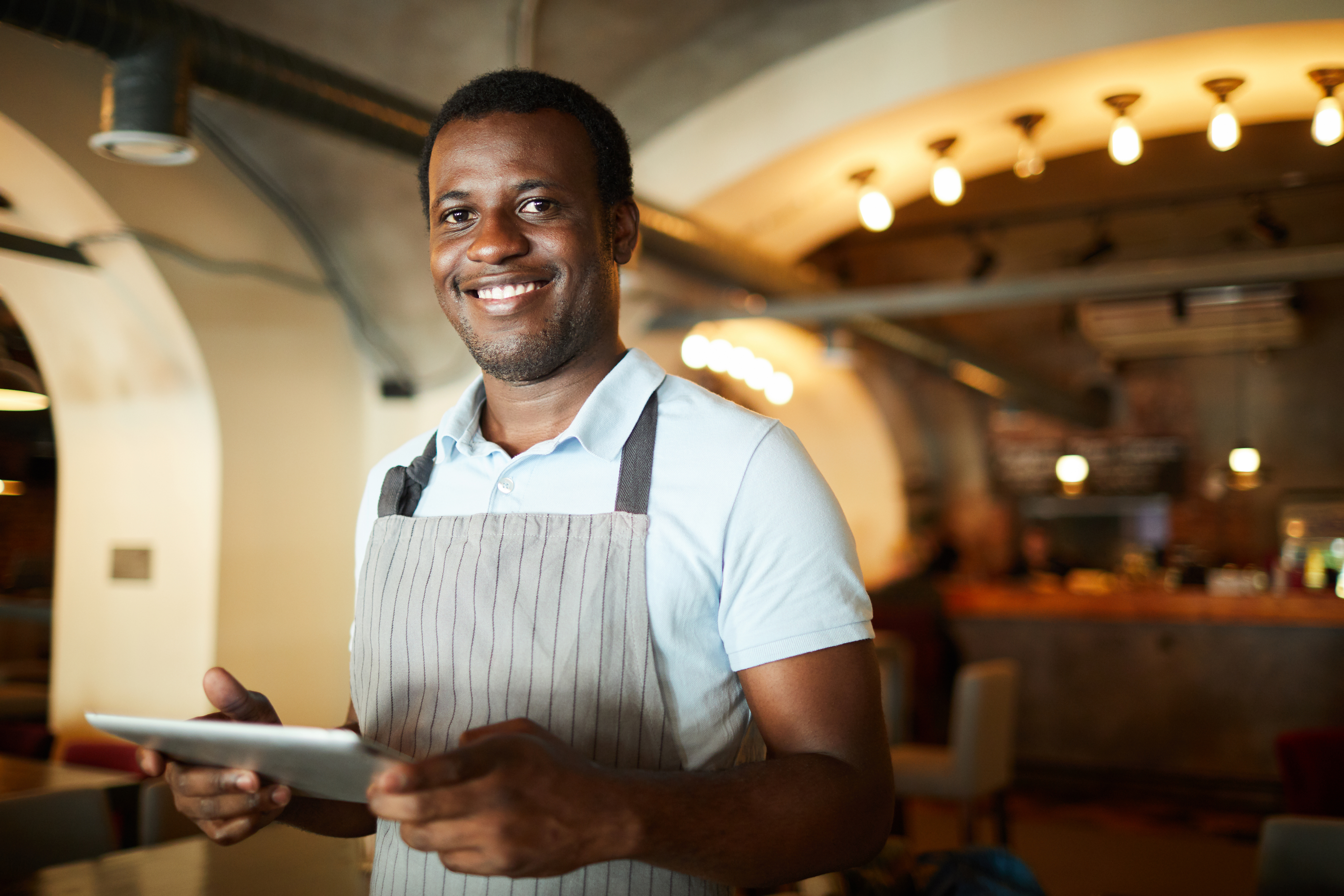 person with apron holding a tablet