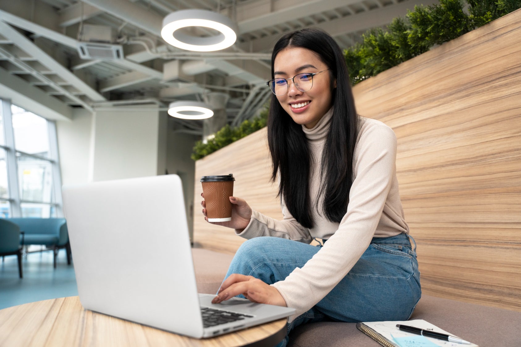 woman with glasses smiling at computer