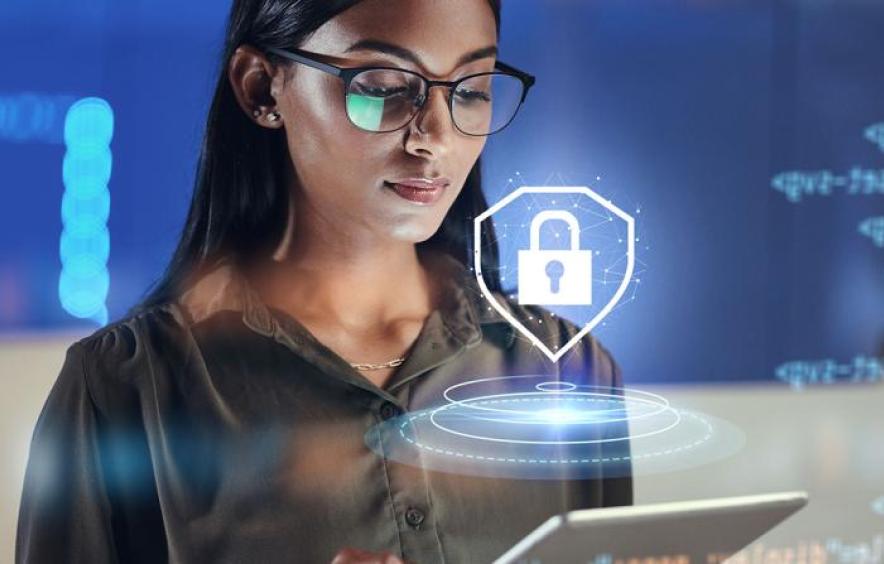 Woman looking at computer with a security lock symbol floating in front of her
