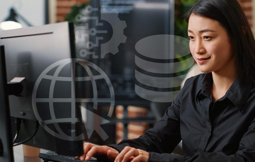Woman working on a computer with data and technology icons displayed